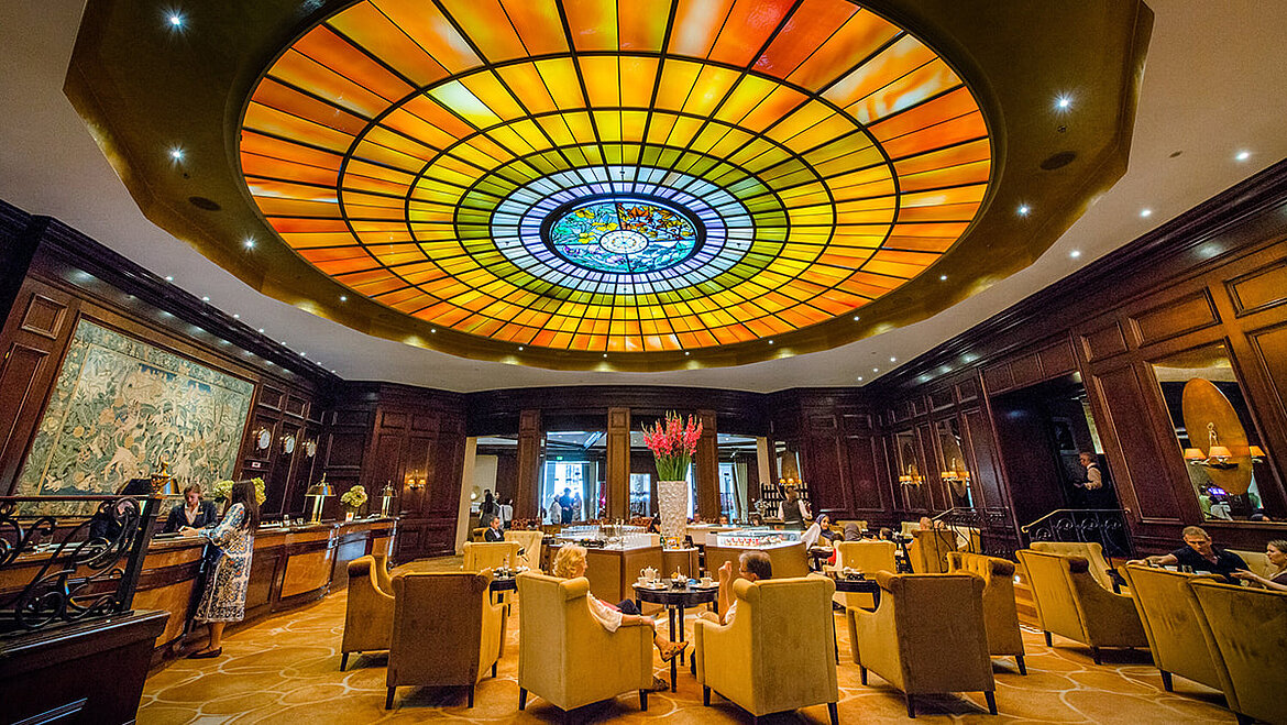 Glasdachpyramide beleuchtet indirekt ein rundes Glasmosaik über Hotellobby