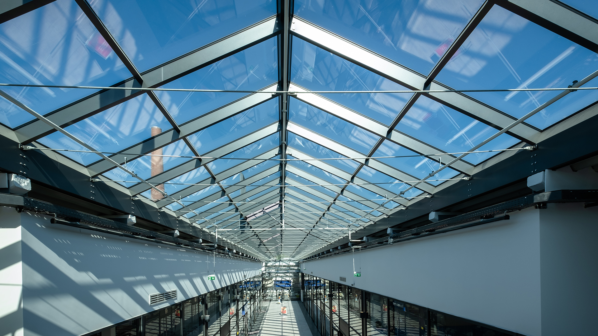 Innenansicht des LAMILUX Glasdach PR60 im Outlet Center Selb mit blauem Himmel.