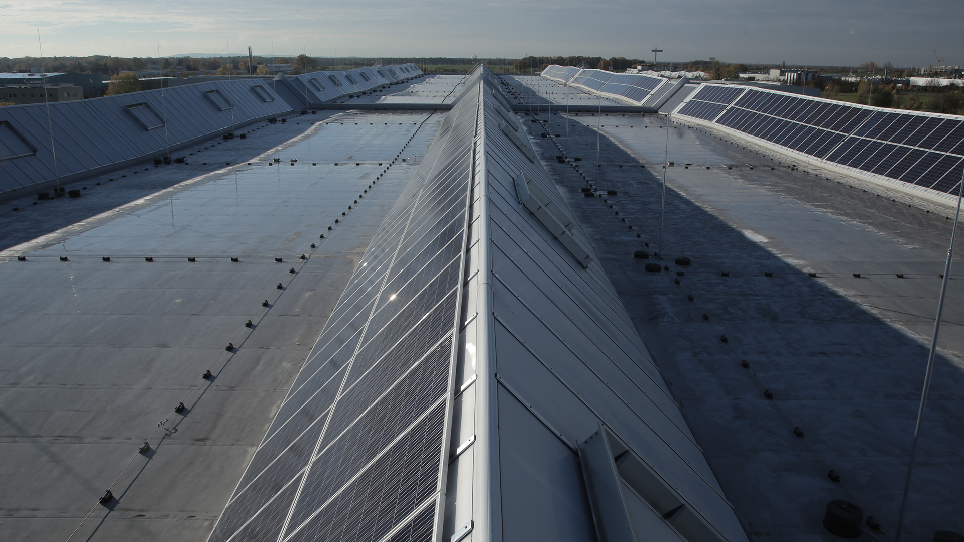 Dach des Logistikzentrums von Rhenus Logistics in Hoppegarten mit LAMILUX Lichtband S und Solarmodulen.