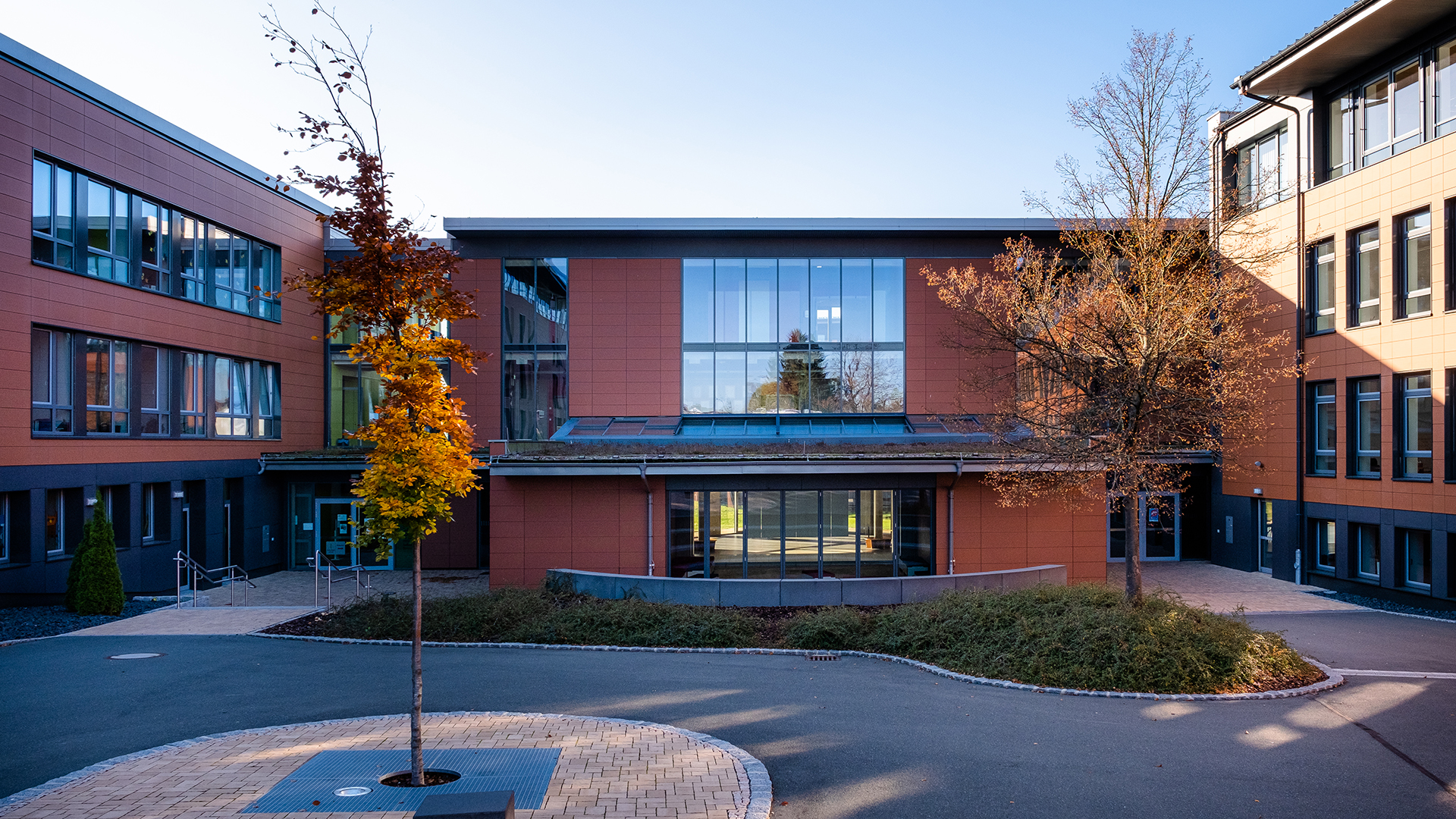 Schulzentrum Rehau mit moderner Architektur, großen Glasfronten und einem begrünten Dach.